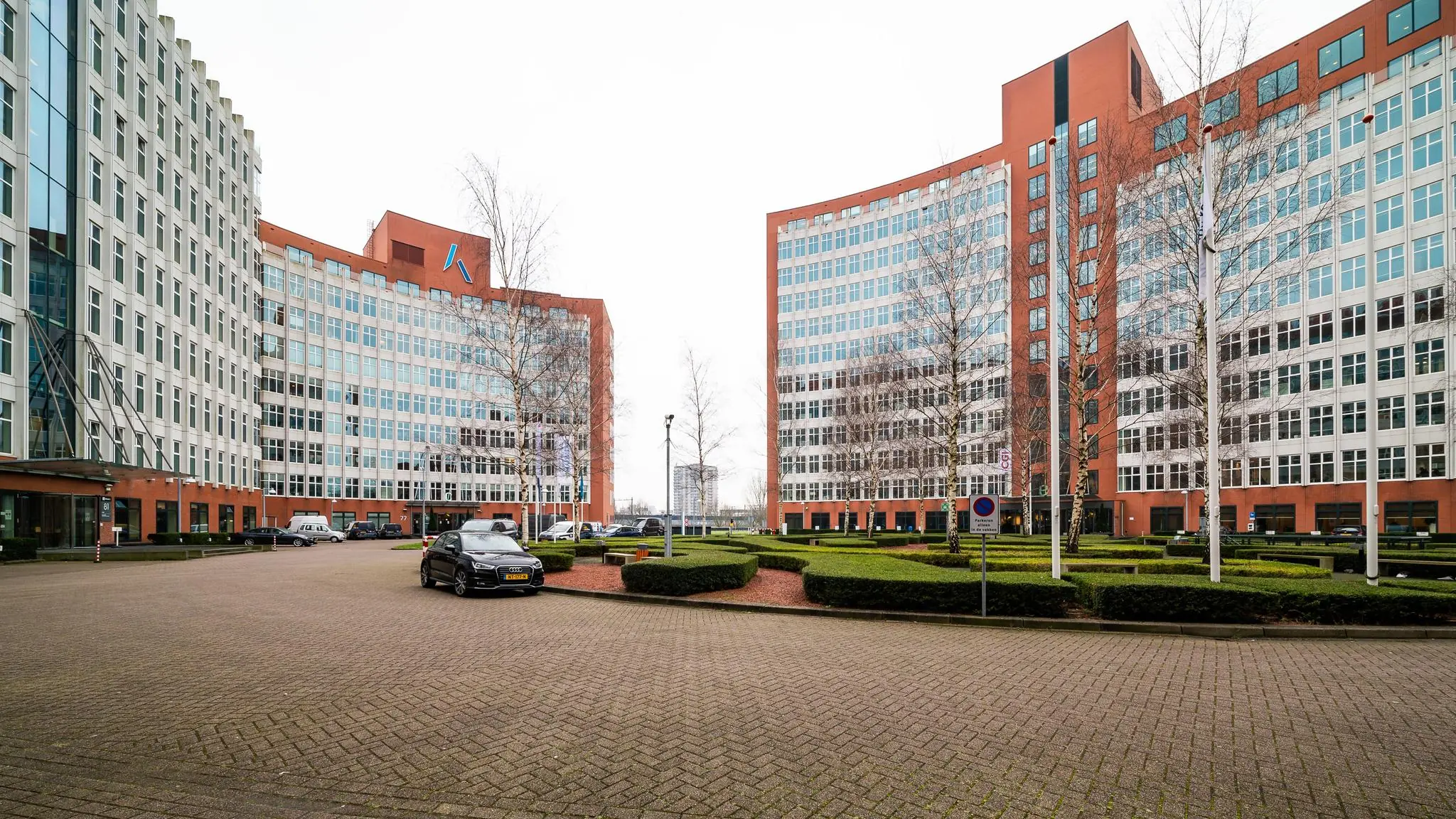 Kantoorgebouwen aan de George Hintzenweg met symmetrische architectuur en verzorgde beplanting op de voorgrond.